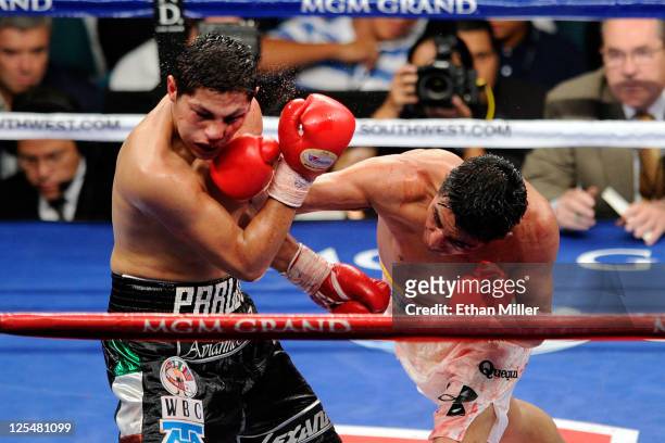 Erik Morales of Mexico connects with a right to the face of Pablo Cesar Cano of Mexico during their WBC super lightweight title fight at the MGM...