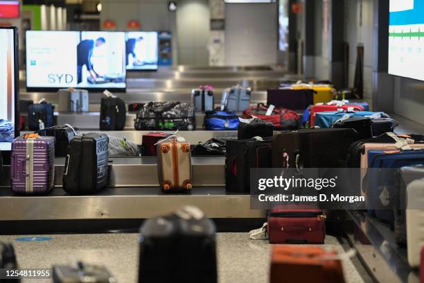 Luggage moves around the carousel in the baggage reclaim hall at Sydney Airport on one of the last flights out of Melbourne to Sydney on July 07,...