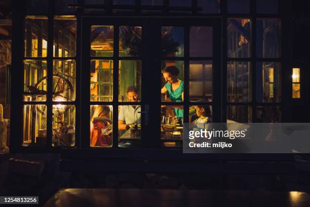glückliche familie beim abendessen im speisesaal - evening meal stock-fotos und bilder