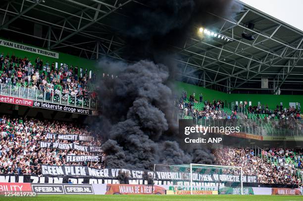 Supporters of FC Groningen among the clouds of smoke during the Dutch premier league match between FC Groningen and Ajax at the Euroborg stadium on...