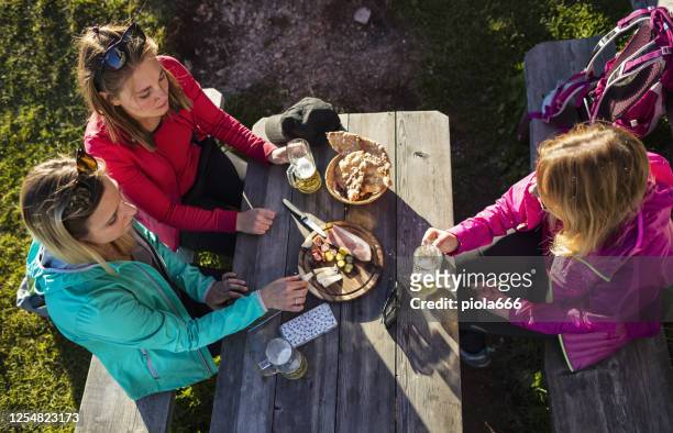 gruppe von frauen beim essen und trinken nach abenteuern in den dolomiten - gardena stock-fotos und bilder