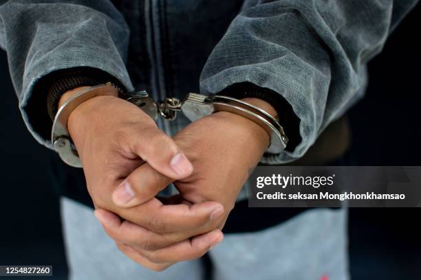 close-up of human hand with handcuffs - sentencing fotografías e imágenes de stock