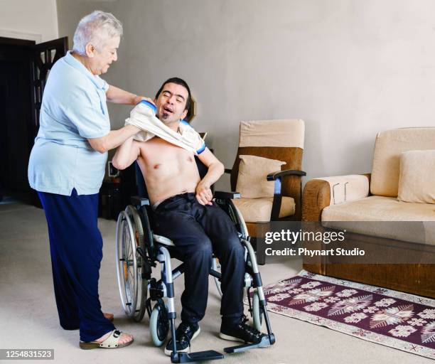 serious disabled young man at home - cerebral palsy stock pictures, royalty-free photos & images