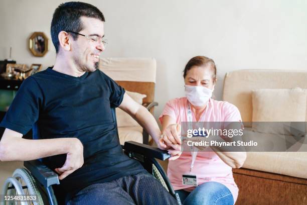 serious disabled young man at coffee shop - brain damage stock pictures, royalty-free photos & images