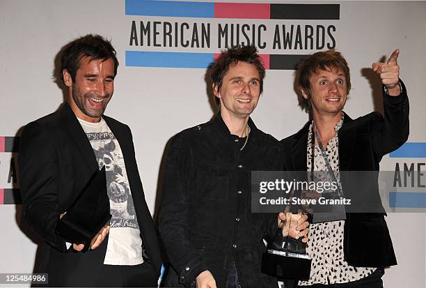 Media manager Tom Kirk with musicians Matthew Bellamy and Dominic Howard of the band Muse pose in the press room at the 2010 American Music Awards...