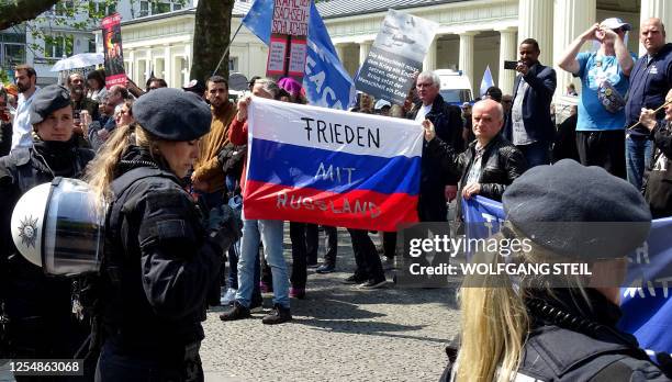 Pro-Russia protesters hold a Russian flag reading "Peace with Russia" as they demonstrate in Aachen, western Germany, where Ukraine's President and...