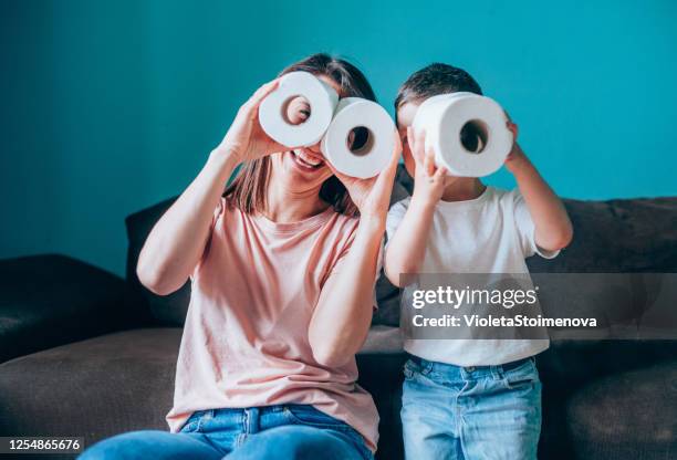 mother and son looking through rolls of toilet paper. - toilet paper stock pictures, royalty-free photos & images