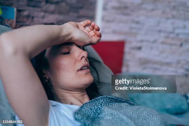 woman with high fever at home. - pandemic illness stock pictures, royalty-free photos & images
