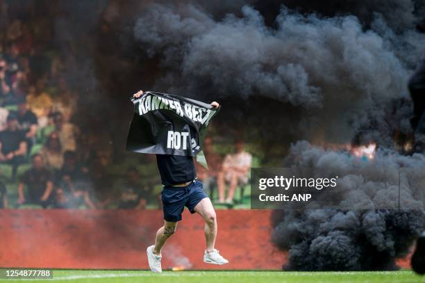 Groningen supporter storms the pitch with a banner during the Dutch premier league match between FC Groningen and Ajax at the Euroborg stadium on May...