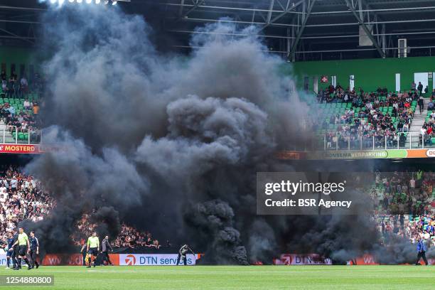 Smoke bombs on the pitch thrown by FC Groningen fans during the Dutch Eredivisie match between FC Groningen and Ajax at Euroborg on May 14, 2023 in...