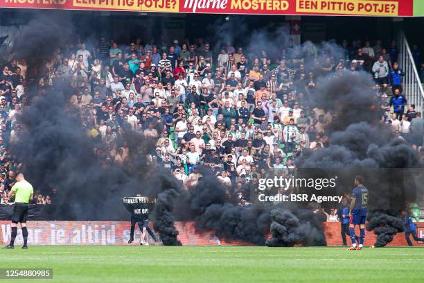 Smoke bombs on the pitch thrown by FC Groningen fans during the Dutch Eredivisie match between FC Groningen and Ajax at Euroborg on May 14, 2023 in...