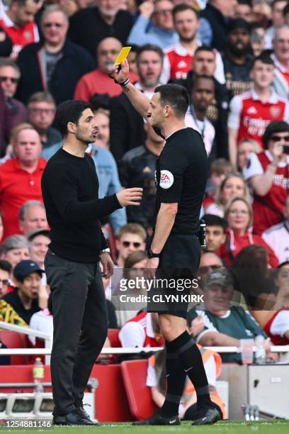 Referee Andrew Madley gives a yellow card Arsenal's Spanish manager Mikel Arteta during the English Premier League football match between Arsenal and...