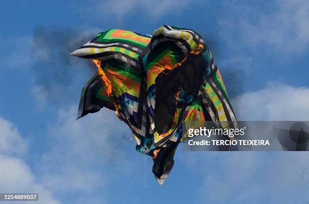 Hot air balloon flown by enthusiasts, without basket nor passengers, burns and falls to land during a tribute to mothers on Mother's Day, in Rio de...