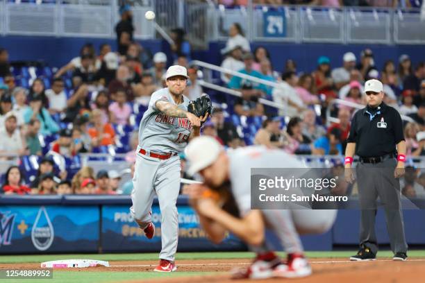 Nick Senzel of the Cincinnati Reds throws the baseball to first baseman Spencer Steer to retire Garrett Hampson of the Miami Marlins during the third...