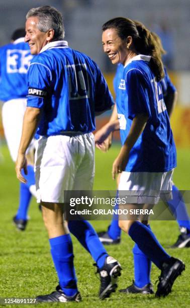 Honduran President, Ricardo Maduro , and the minister of Art and Cultures, Mireya Batres, walk on a soccer field during a fund raising event for the...