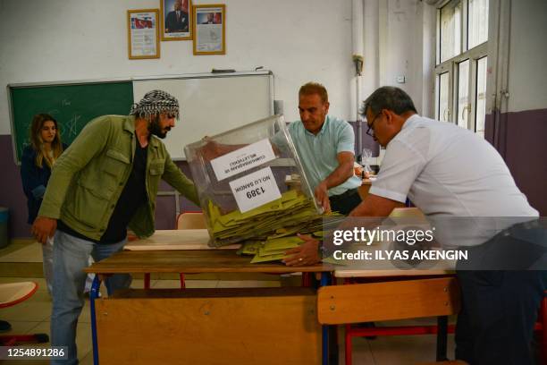 Election officials count ballots at a polling station after polls have closed in Turkey's presidental and parliamentary elections, in Diyarbakir, on...