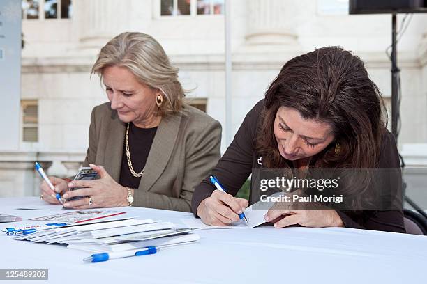 Vicki O'Meara, Executive Vice President and President, Pitney Bowes Management Services, and singer/songwriter Amy Grant sign holiday cards at the...