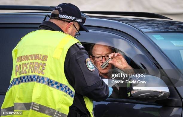 Driver shows a permit as police stop and question drivers at a checkpoint on July 8, 2020 in Albury, Australia. The NSW-Victoria border closed at...