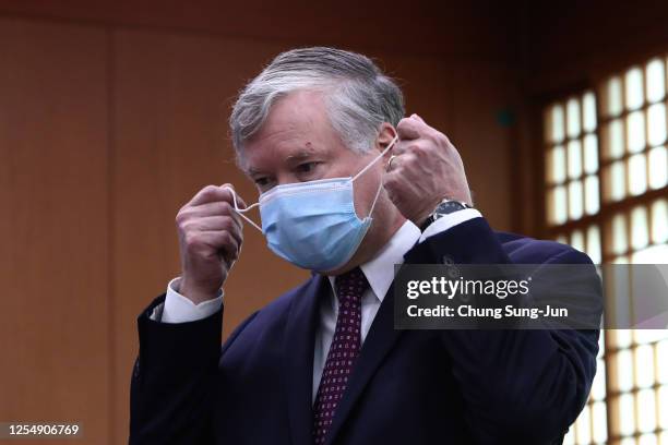 Deputy Secretary of State Stephen Biegun takes off mask before a meeting with South Korea's Foreign Minister Kang Kyung-wha at the foreign ministry...