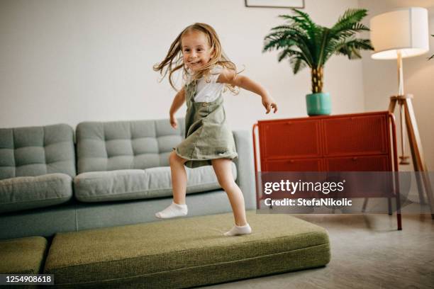 kind springt auf sofa - jump on sofa stock-fotos und bilder