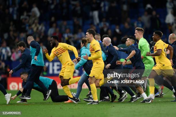 Barcelona's players leave the pitch in a hurry as Espanyol fans invade the pitch after the Spanish league football match between RCD Espanyol and FC...