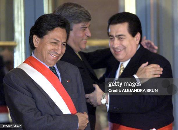 Peruvian President Alexander Toledo and incoming minister of justice Fausto Alvarado greet former Minister Fernando Olivera, after the swearing in...