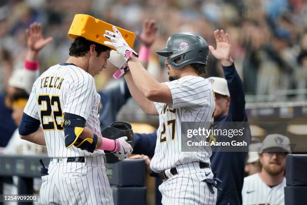 Christian Yelich of the Milwaukee Brewers celebrates with teammate Willy Adames after hitting a home run during the first inning of the game between...