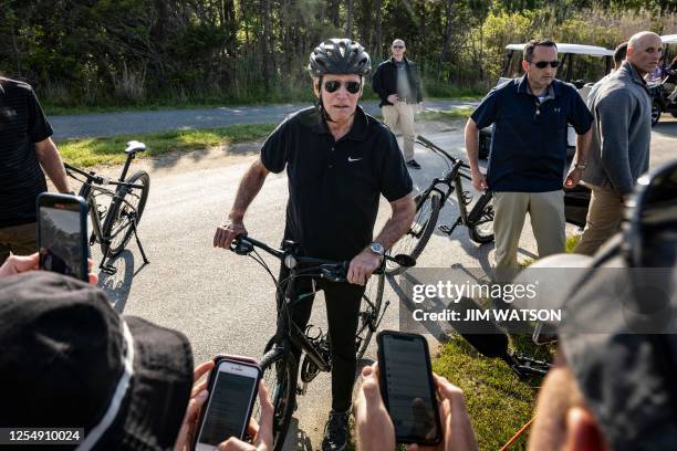 President Joe Biden stops to speak with the White House Press Corps as he rides through Cape Henlopen State Park in Rehoboth Beach, Delaware on May...