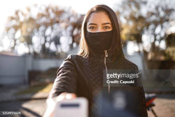 delivery woman receiving payment- motogirl, motoboy - motoboy stock pictures, royalty-free photos & images