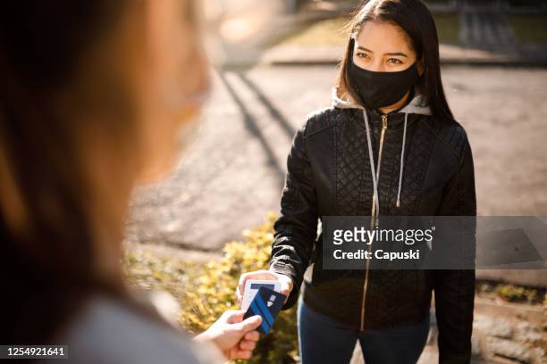 customer paying the delivery woman by credit card- motogirl, motoboy - motoboy stock pictures, royalty-free photos & images