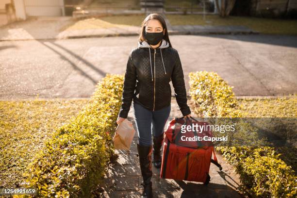 delivery woman arriving on destination with package- motogirl, motoboy - motoboy stock pictures, royalty-free photos & images