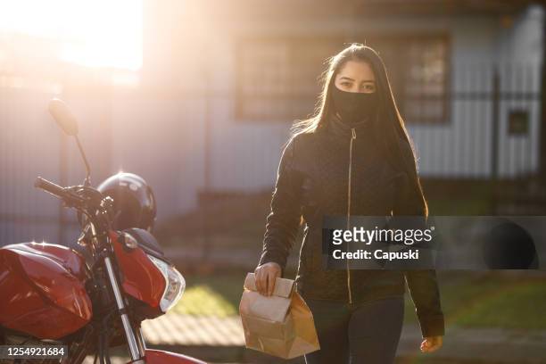 woman delivering package- motogirl, motoboy - motoboy stock pictures, royalty-free photos & images