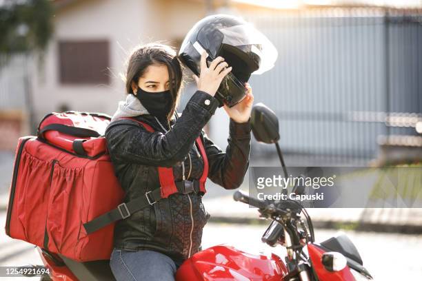 delivery biker taking crash helmet off- motogirl, motoboy - motoboy stock pictures, royalty-free photos & images