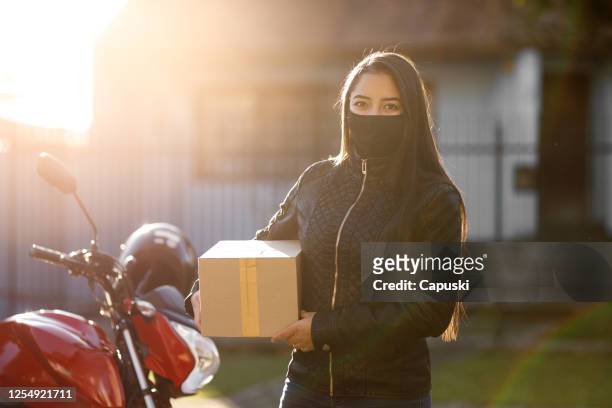 woman delivering package- motogirl, motoboy - motoboy stock pictures, royalty-free photos & images