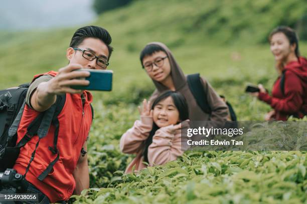 asiatische chinesische tourist auf cameron highland tee ernteplantage genießen die schönheit der natur und frische der luft in der morgen selfie mit seiner familie - cameroon stock-fotos und bilder