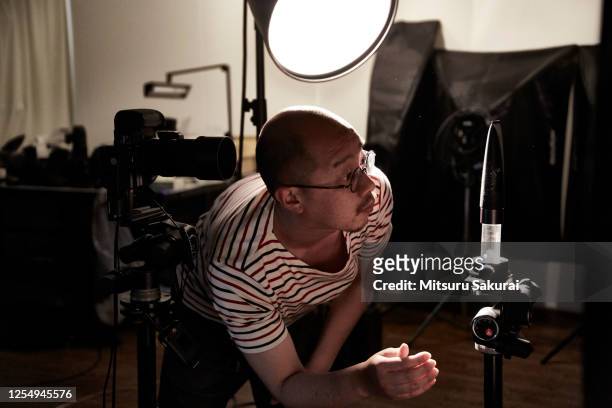 the photographer is shooting alone in the studio - photographer stock-fotos und bilder