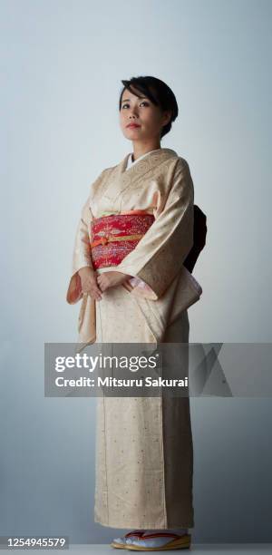 a japanese woman in a cool kimono against gray background - kimono stockfoto's en -beelden