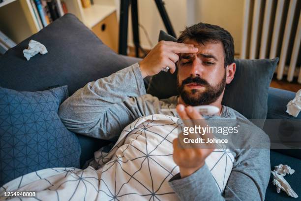sick man checking the temperature - symptom stock pictures, royalty-free photos & images