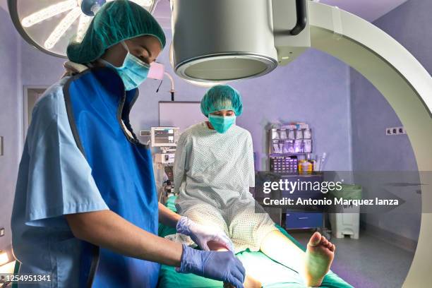 doctor examining patient in x-ray machine in operating room - co ordination stock pictures, royalty-free photos & images