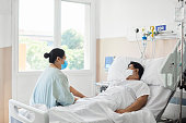 Woman Visiting Male Patient in Hospital Ward