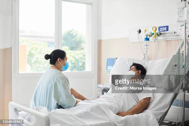 woman visiting male patient in hospital ward - visit stock pictures, royalty-free photos & images