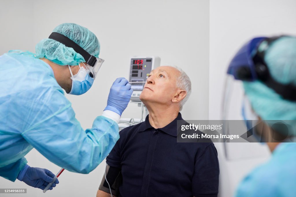 Doctor Taking Coronavirus Sample From Male's Nose, PCR.
