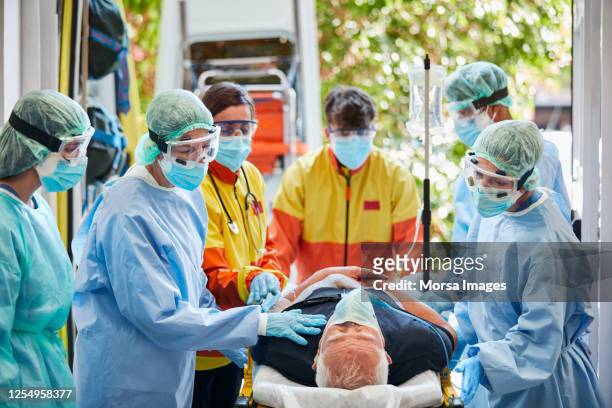 operatori sanitari con paziente con coronavirus maschile - evento catastrofico foto e immagini stock