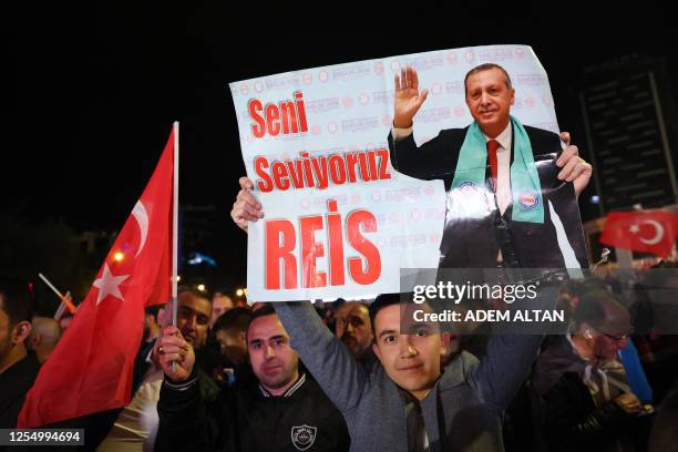 Supporter of Turkish President Tayyip Erdogan holds a poster which reads "We Love You Chief" outside the AK Party headquarters after polls closed in...
