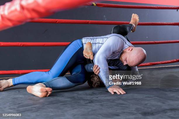 jiu-jitsu training in fighting ring stock photo - mixed martial arts stock pictures, royalty-free photos & images