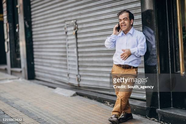 gentleman talking on mobile on the street - dwarf stock pictures, royalty-free photos & images