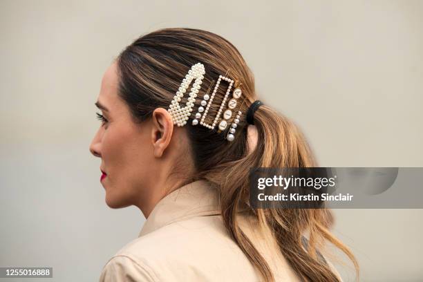 Guest wears pearl hair slides and clips on March 03, 2020 in Paris, France.