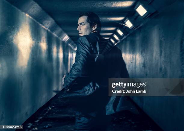 man running through dingy underground walkway. - fugitive stock-fotos und bilder