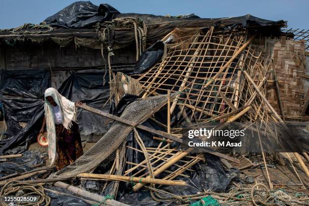 Woman collecting her belonging after Cyclone Mocha'a landfall at Shah Porir dwip in Teknaf.