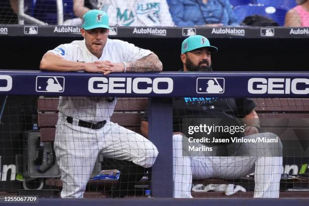 Skip Schumaker Manager of the Miami Marlins and Rod Barajas field coordinator watch the game against the Cincinnati Reds from the dugout at loanDepot...